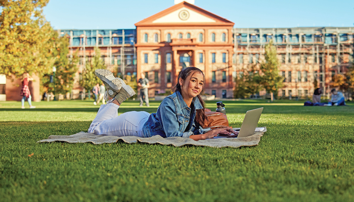 student studying on campus lawn