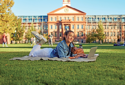 student studying on campus lawn