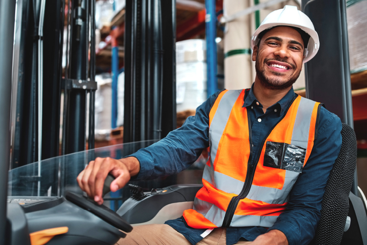 Construction man sitting on machine smiling.