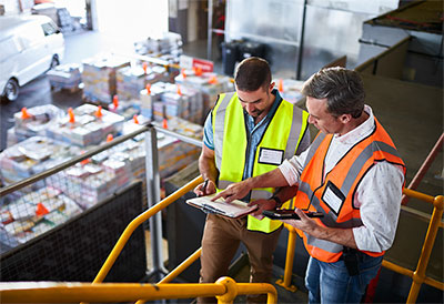 Two men looking at a clipboard on factory floor