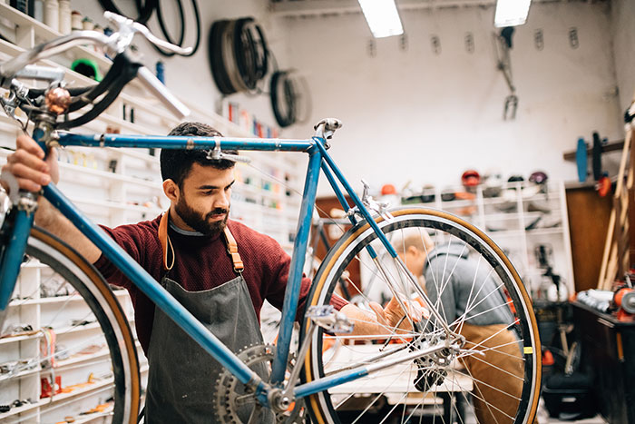 Man repairing a bicycle in a bike shop.