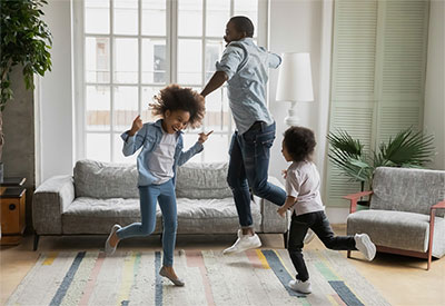 Dad dancing in the living room with his two daughters.
