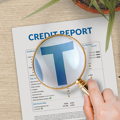 Credit report with a magnifying glass showing a blue T.