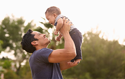 Father holding up infant son.