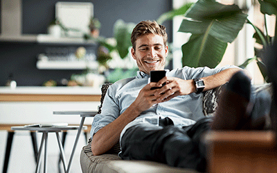 Man on couch scrolling through his phone