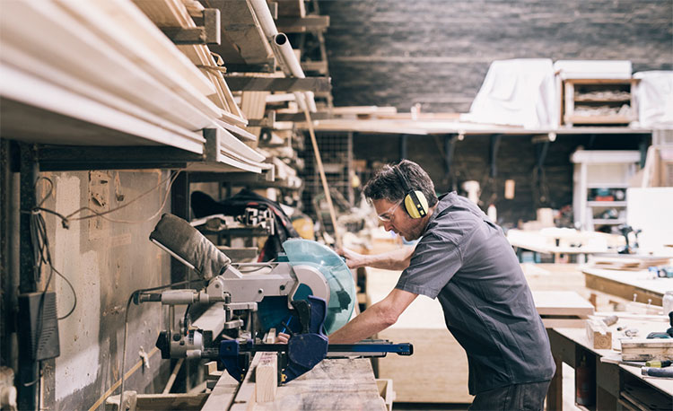 Man using a table saw in a workshop.