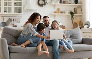 Family on couch looking at laptop