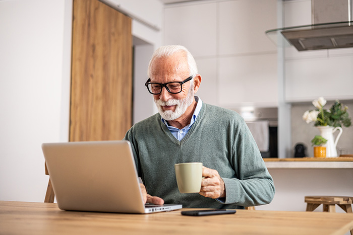 elderly looking at his laptop