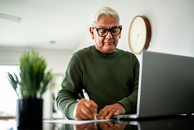 elderly man taking notes